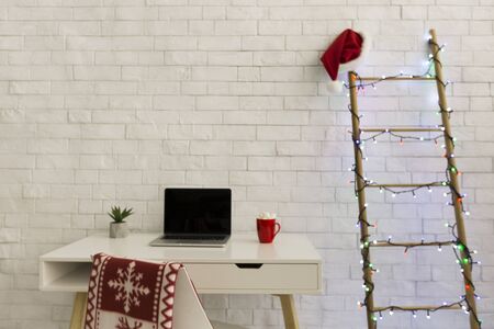 Workplace at home decorated for Christmas, laptop with black blank screen, copy spaceの写真素材