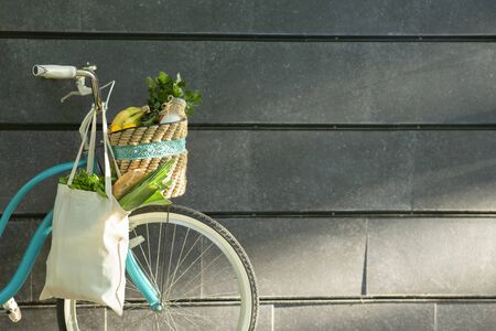 Eco friendly Bicycle with organic vegetables in cotton reusable bag over concrete wall, copy spaceの写真素材