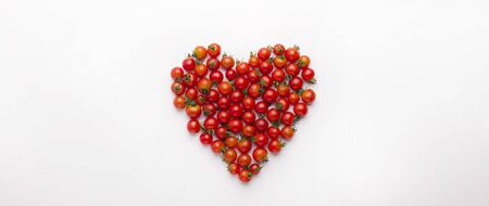 Creative vegetarian concept. Heart shaped cherry tomatoes isolated on white panoramic background, copy spaceの写真素材