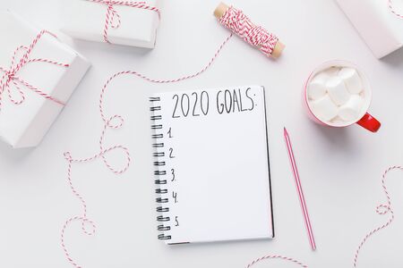 Time to writing New Year plans. Creative holiday background with presents and notebook with 2020 goals, copy spaceの写真素材