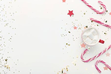 Xmas concept. Christmas composition of chocolate with marshmallow and sweet candy canes on white, copy spaceの写真素材