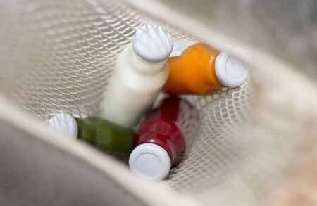 Healthy lifestyle. Colored detox drinks inside zero waste shopping bag, blurred background