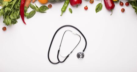 Prevention of disease. Stethoscope and vegetables for saving healthy in winter isolated on white, panorama, copy spaceの写真素材