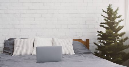 Home cozy interior with Christmas tree and modern laptop, panorama, copy spaceの写真素材