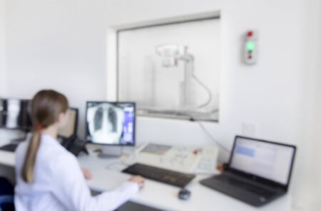 Blurred photo of woman doctor analyzing X-ray snapshot, modern laboratory interior, copy spaceの写真素材