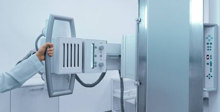 Woman hand holding X-ray machine in modern medical laboratory, panorama, copy space