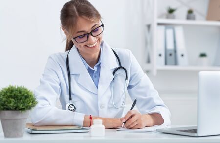 Positive Female Therapist Prescribing Pills Sitting In Clinic Office. Selective Focusの写真素材