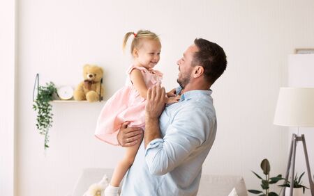 Adopted Child. Happy millennial father hugging his foster child, spending time with daughter. Copy spaceの写真素材