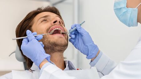 Close up of man with open mouth sitting in dentist chair, panoramaの写真素材