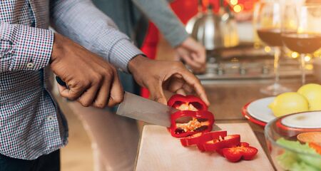 Fresh ingredients only. African-american man cutting natural paprika for salad, panoramaの写真素材