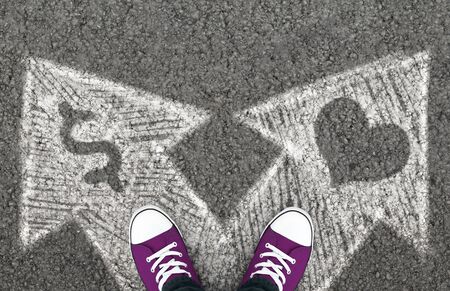 Money Or Love. Choice between cash and feelings. Crossroad with drawn arrows, top view.