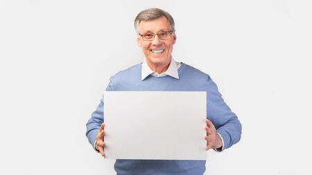Great Offer. Cheerful Elderly Man Holding Blank Board For Text Standing Over White Studio...