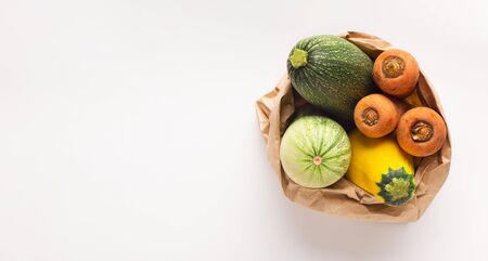 Fresh and tasty zucchini, carrots and squash in zero waste bag on white background, panorama, copy spaceの写真素材