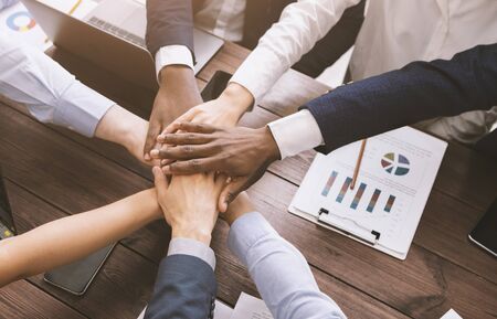 Business collaboration. Top view on diverse corporate team hands stacked together in office, top viewの写真素材