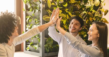 Successful business team giving group high five in cafe, panorama