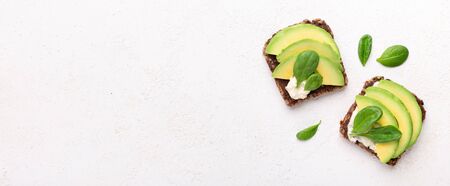 Healthy breakfast. Wholegrain toasts with tofu, avocado and spinach, isolated on white panorama background, empty spaceの写真素材
