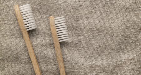 Save the planet or NO plastic concept. Two eco bamboo toothbrushes on natural fief background, panorama, copy spaceの写真素材