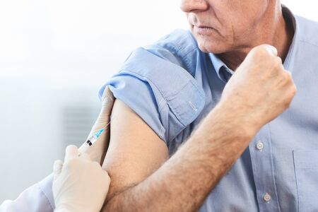 Close Up Of Unrecognizable Doctor Doing Vaccination To Elderly Man, Copy Space