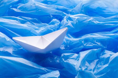 Small boat sailing in ocean full of garbage, plastic, litter, ecology problem, ecosystem damage...