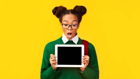Awesome Application Or Website. Excited black girl showing blank tablet screen for advertising, mock up, copy spaceの写真素材