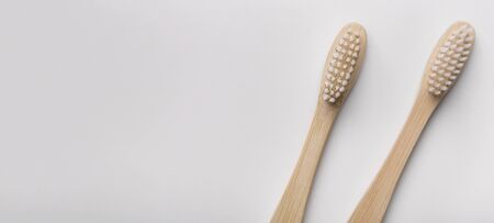 Save the planet or NO plastic concept. Two eco natural bamboo toothbrushes on white background, panorama, copy spaceの写真素材