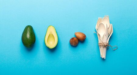 Eco plastic disposable tableware of natural avocado seeds, blue background, panorama