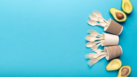 Creative frame of new eco plastic products of avocado seeds, isolated on blue background, copy space