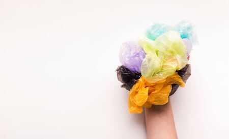 Zero waste lifestyle concept. Hand with colored plastic bags isolated on white background, panorama, copy spaceの写真素材