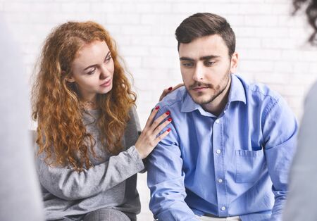 Group support. Woman comforting depressed addict man at rehab meeting, free spaceの写真素材