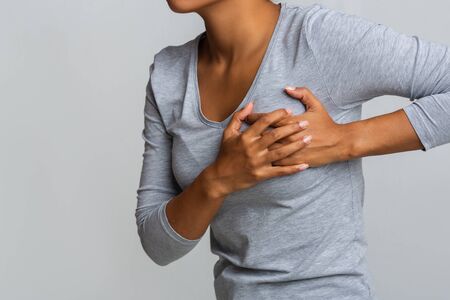 Health problem. Young african woman feeling menstrual cyclic breast pain, touching her chest, close...