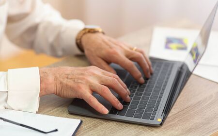 Closeup Of Senior Man's Hands Working Typing On Laptop Sitting In Office. Selective Focus, Cropped