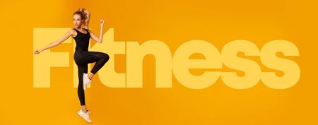 Fit Young Woman Exercising Jumping In Studio Over Fitness Letteringの写真素材