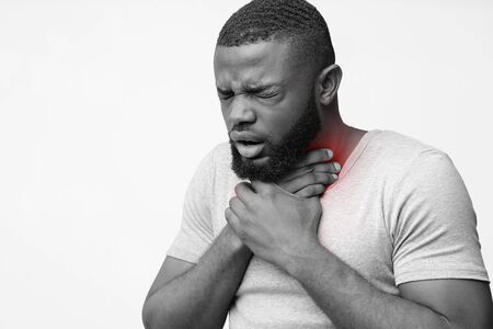 Young unhealthy black guy coughing, has sore throat, loss of voice after loud screaming, free space