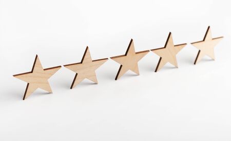 Wooden five star shape on white background. The best excellent business services rating customer...