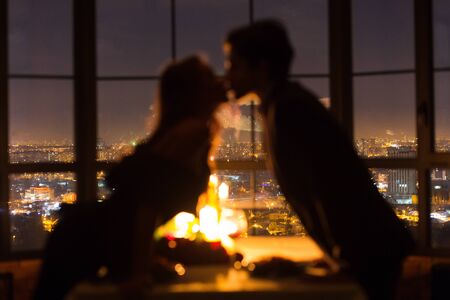 Couple kissing on romantic date, celebrating Valentines Day together at restaurant, side viewの写真素材