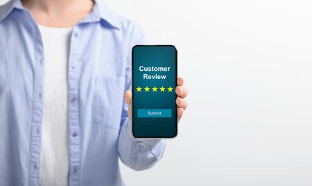 Girl holding mobile phone with customer review text on screen with five star scale, white...