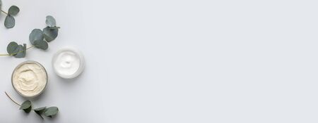 Herbal dermatology cosmetic hygiene cream with olive oil skincare product in glass jar on gray background, wide panorama, copy spaceの写真素材