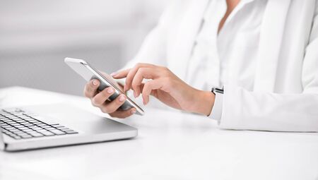 Modern Technologies. Closeup of female hands, latin girl using mobile phone, writing post. Free...