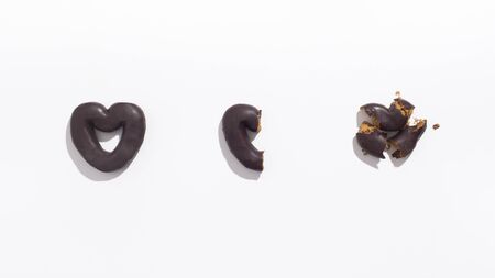 Saint Valentines Day or divorce concept. Heart shape Chocolate cookie broken on small pieces on white background, panoramaの写真素材