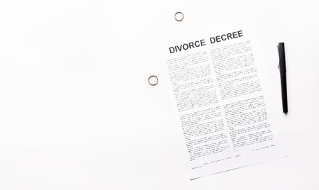 Divorce and separation concept. Divorce decree law document, engagement rings and pen on white background, copy spaceの写真素材