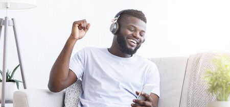 Positive black man listening to favorite music online, panoramaの写真素材