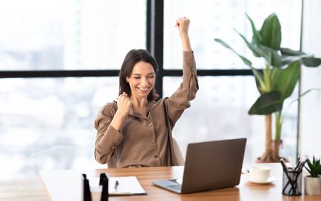 Hooray. Excited businesswoman found solution to problem, celebrating success with raised arm, copyspaceの写真素材