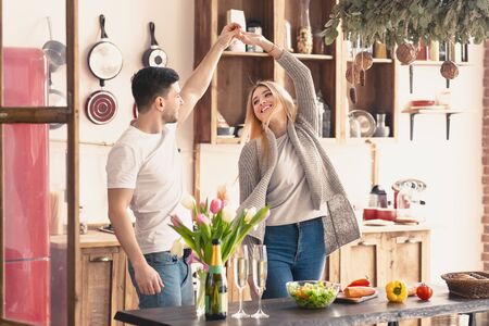 Happy couple dancing at home on kitchen. Romantic rest, man and woman having funの写真素材