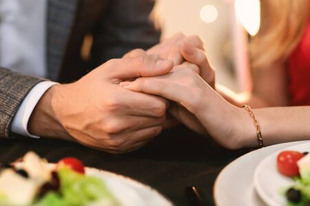 Love Declaration. Closeup Of Romantic Couple Holding Hands On Date Dinner In Restaurant, Full Of Feelings To Each Other, Cropの写真素材