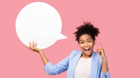 Amazing Offer. Overjoyed girl holding empty speech bubble, pointing finger up, pink studio wall, copyspaceの写真素材