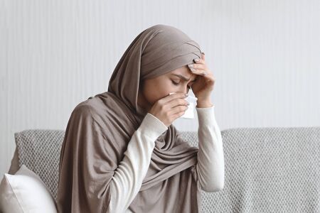 Sick Islamic Woman In Hijab Touching Forehead, Suffering From Flu At Home, Having Temperature And...
