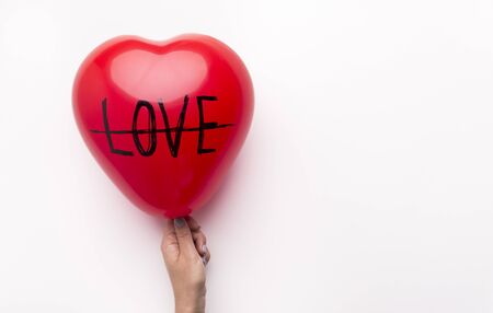 Divorce concept. Crossed out love text on heart balloon on white background with copy space for text