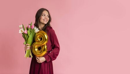 International Womens Day Celebration. Beautiful young girl holding figure 8 shape balloon and tulip...