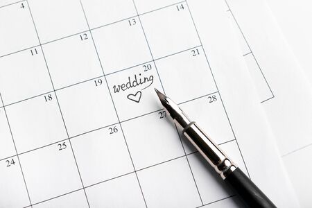 A note on a calendar with heart sets a reminder for the wedding dayの写真素材