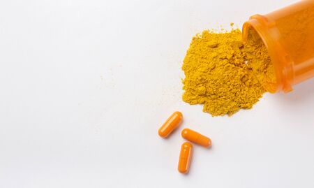 Flat lay of finely dry Turmeric powder and capsules isolated on white background, panorama, copy spaceの写真素材